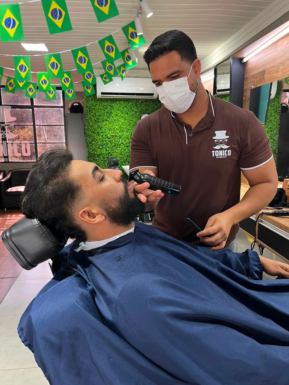 Tonico cortando cabelo de cliente